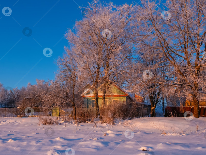 Скачать Очаровательный деревянный дом стоит в заснеженной сельской местности фотосток Ozero