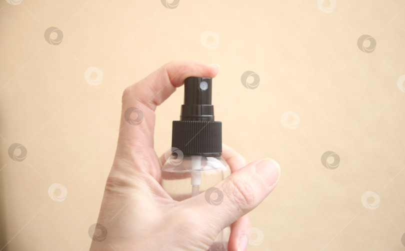 Скачать Женская рука держит флакон со средством  для уборки фотосток Ozero