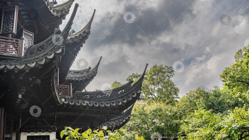 Скачать Детали китайской архитектуры. Крыша здания украшена резными изогнутыми карнизами. фотосток Ozero
