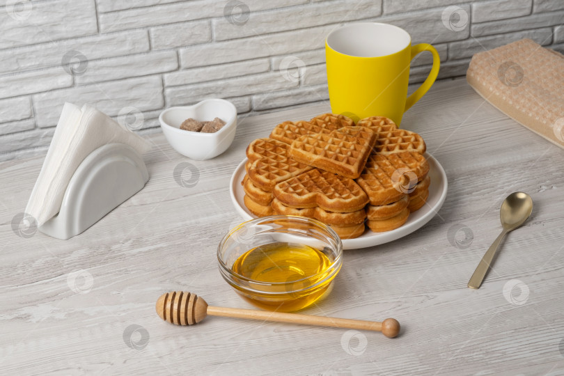 Скачать Вафли в форме сердечка подаются на тарелке с медом и сиропом рядом фотосток Ozero