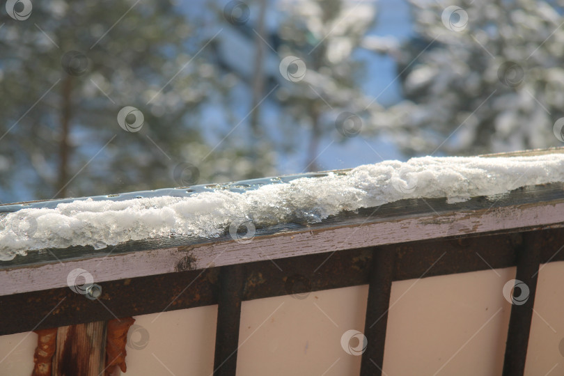 Скачать на деревянных перилах тает снег, фотосток Ozero