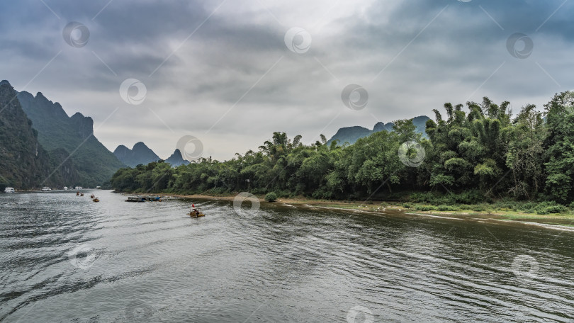 Скачать По руслу реки плывут туристические суда и бамбуковые плоты. фотосток Ozero