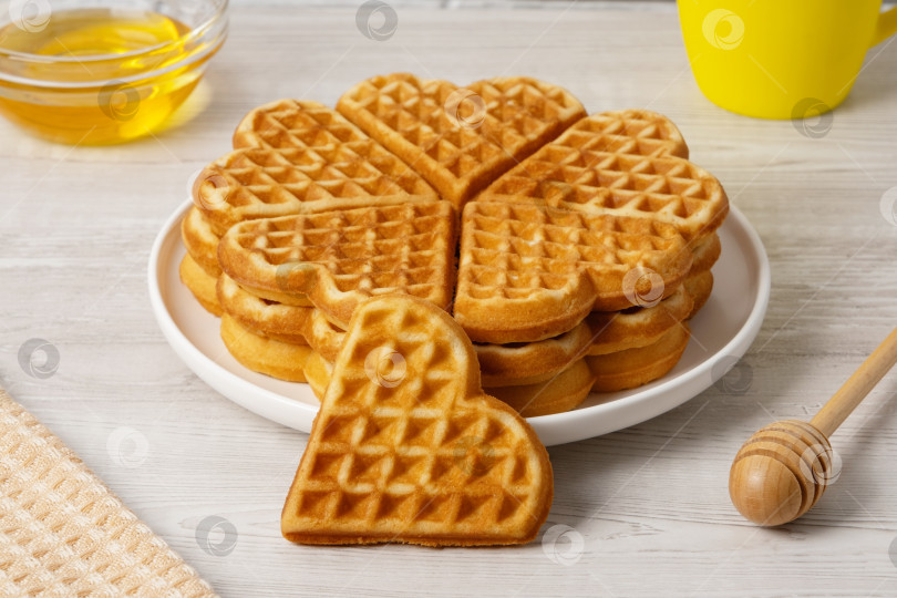 Скачать Вафли в форме сердца подаются на тарелке с медом и сиропом рядом фотосток Ozero