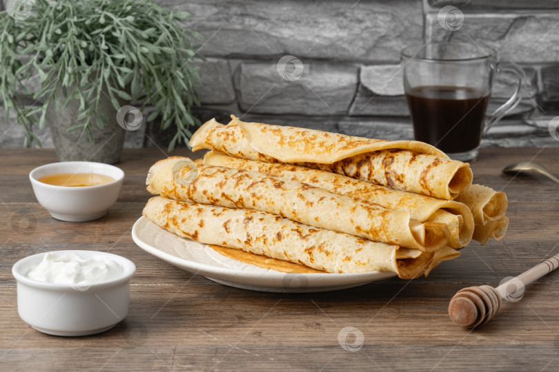 Скачать Блинчики подаются на тарелке с медом, сметаной и кофе на деревянном столе фотосток Ozero