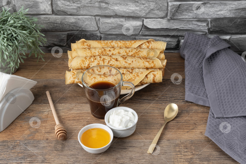 Скачать Блинчики подаются на тарелке с медом, сметаной и кофе на деревянном столе фотосток Ozero