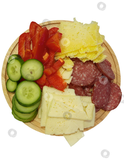 Скачать Огурец, болгарский перец, сыр, колбаса нарезаны, лежат на деревянном блюде. Аппетитная закуска. Белый  фон . фотосток Ozero
