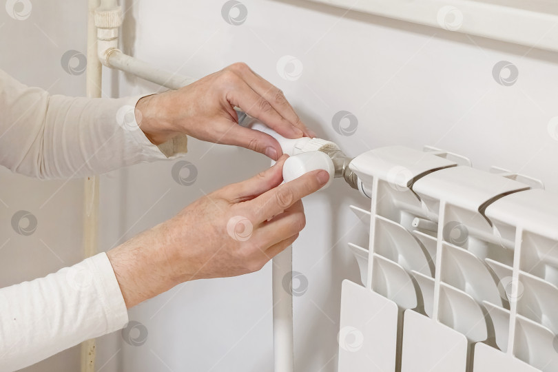 Скачать Крупным планом изображен термостат радиатора с рукой человека-будильщика. фотосток Ozero