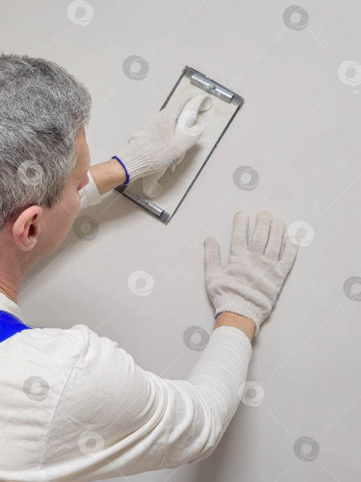 Скачать Вертикальный вид руки рабочего и инструмента для шлифования шпаклевки. фотосток Ozero