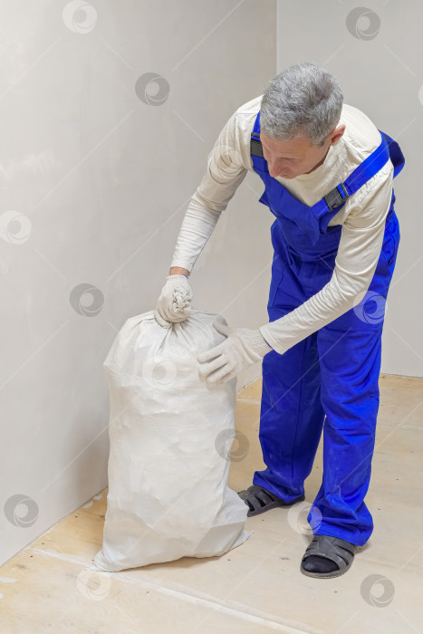 Скачать Мужские руки складывали строительный мусор в белый пакет фотосток Ozero