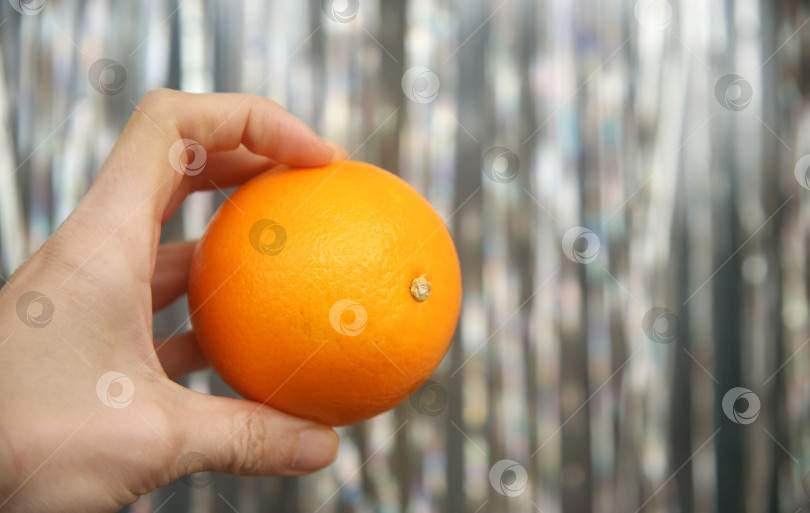 Скачать Фрукт апельсин  в женской руке фотосток Ozero