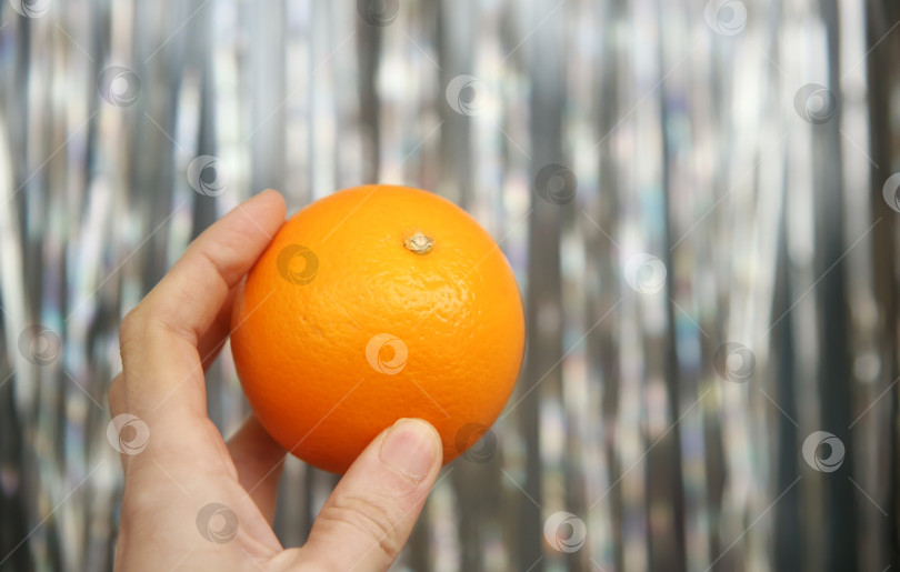 Скачать Апельсин в женской руке фотосток Ozero