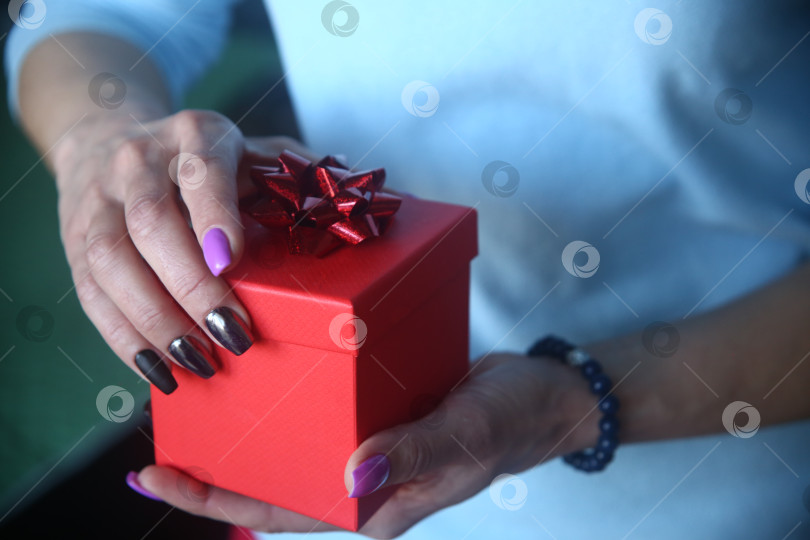 Скачать Женщина открывает подарок на 8 марта. Международный женский день фотосток Ozero