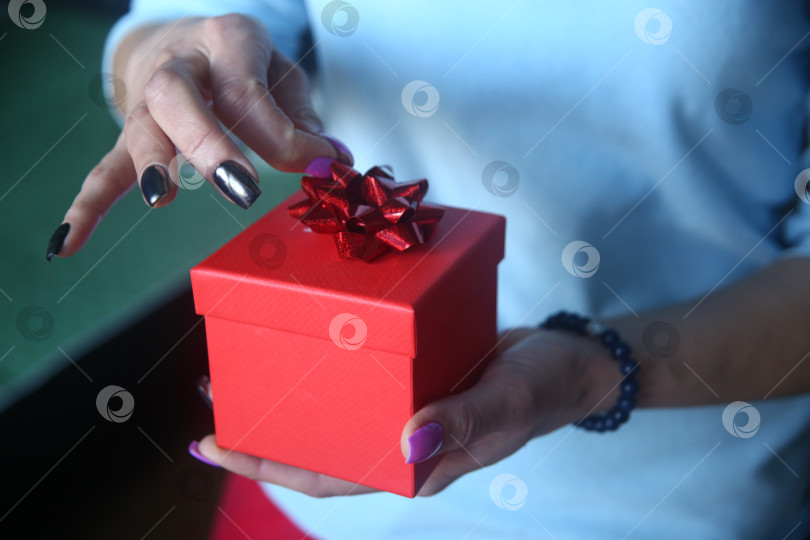 Скачать Женская рука держит подарок на 8 марта фотосток Ozero