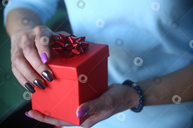 Скачать Женская рука держит подарок. Международный женский день фотосток Ozero