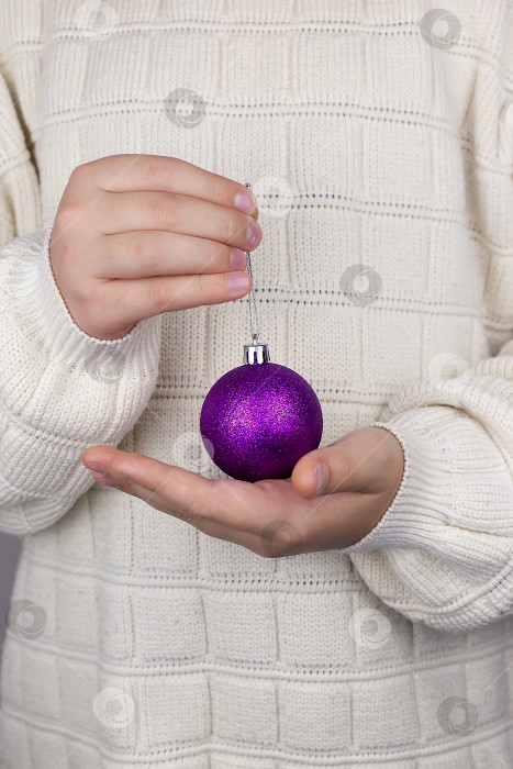 Скачать концепция Рождества, украшений, праздников и людей - крупным планом женская рука, держащая рождественский шар над гостиной. фотосток Ozero