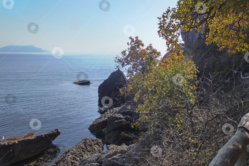 Скачать Синее Черное море с горой вдалеке. Справа и ниже видны скалы с зеленью и фрагмент ограждения фотосток Ozero