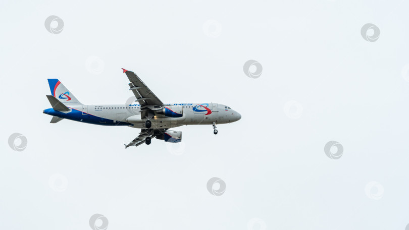 Скачать Sukhoi Superjet-100 SSJ-100-95LR заходит на посадку на взлетно-посадочную полосу аэропорта Адлер. Авиакомпания "Азимут". Выпущены шасси самолета и механики крыла. фотосток Ozero