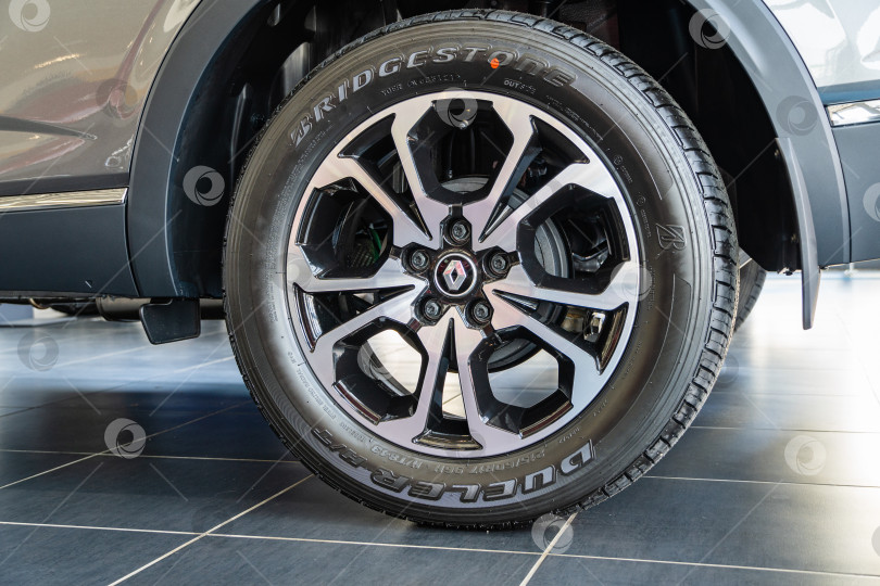Скачать Серый внедорожник Renault Arkana в автосалоне. Шина Bridgestone установлена на литой алюминиевый обод. Крупный план заднего левого колеса. Автосалон Renault в Мега Адыгея. Краснодар, Россия - 26 августа 2021 г. фотосток Ozero