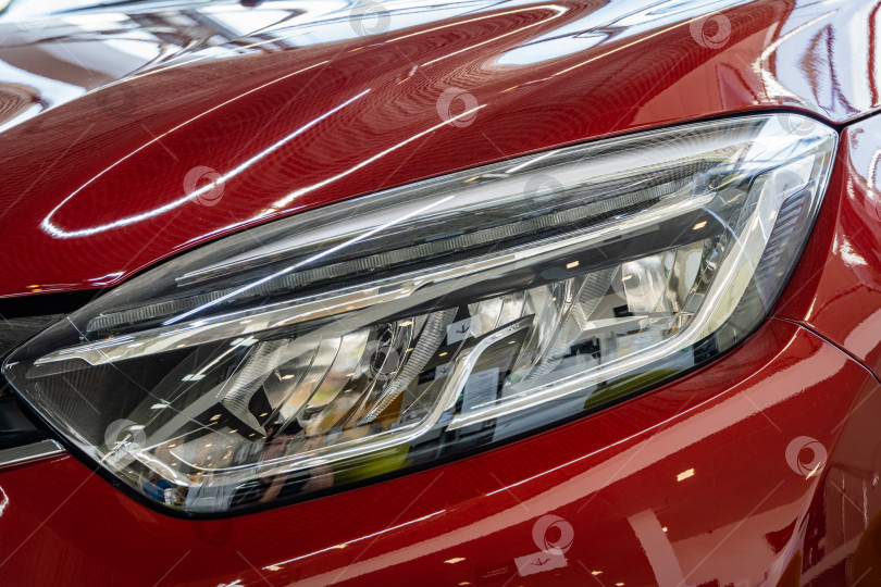 Скачать Красный внедорожник Renault Captur в автосалоне. Передняя левая фара крупным планом. Автосалон Renault в Мега Адыгея. K фотосток Ozero