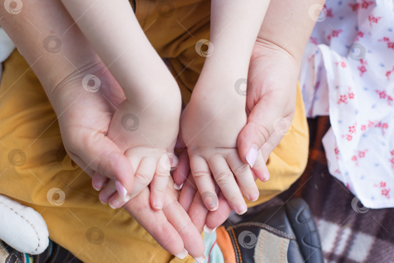 Скачать Руки маленького ребенка, парализованного, в руках его матери. Поддержка семьи. Материнская любовь. Инвалидность. ребенок-инвалид фотосток Ozero