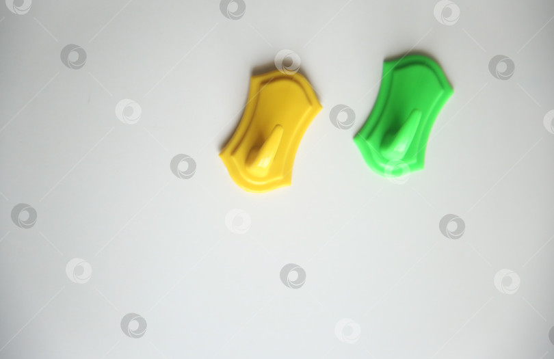 Скачать Жёлтый и зеленый крючки для полотенец на столе. Групповым планом разработано фотосток Ozero