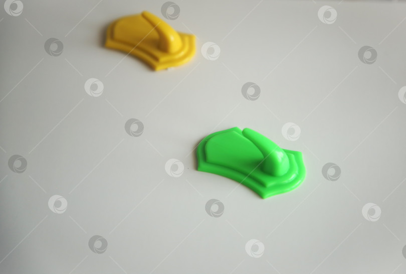 Скачать Жёлтый и зеленый крючки для полотенец на столе. Изолировано на белом фотосток Ozero