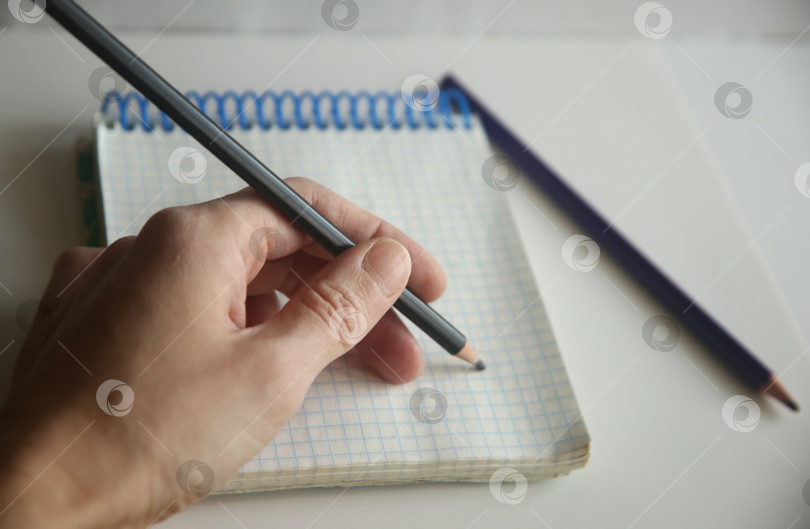 Скачать Женщина пишет карандашом в блокноте фотосток Ozero