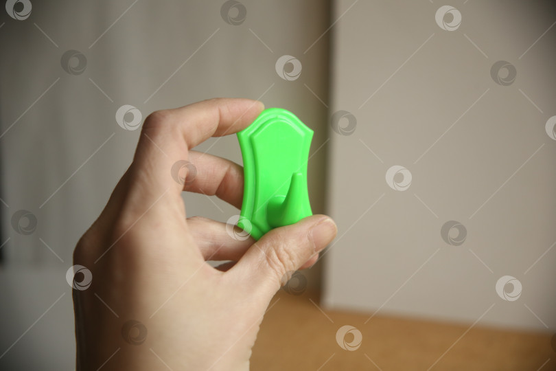 Скачать Зеленый крючок для полотенца в руке фотосток Ozero