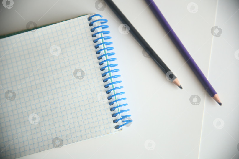 Скачать Школьные атрибуты карандаши и блокнот в клетку, крупный план фотосток Ozero