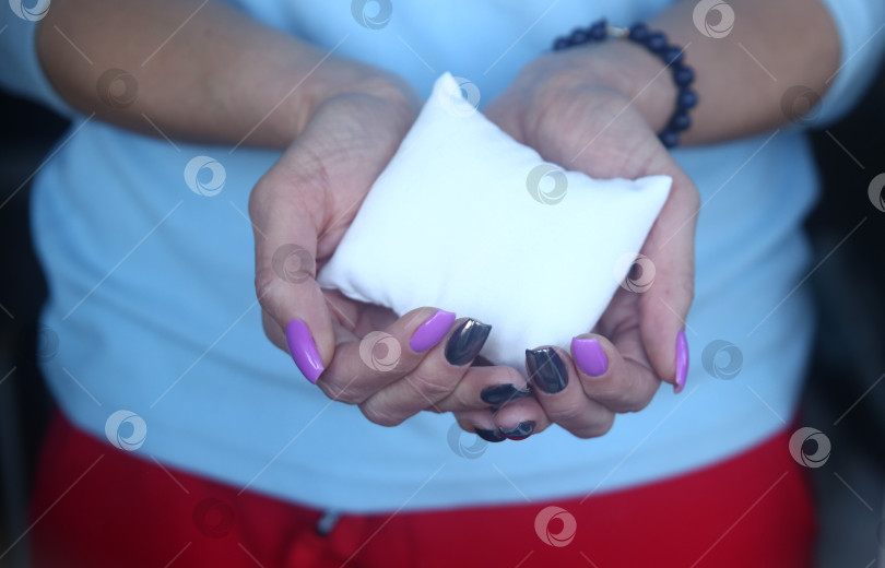 Скачать Маленькая подушка в женской руке крупным планом фотосток Ozero