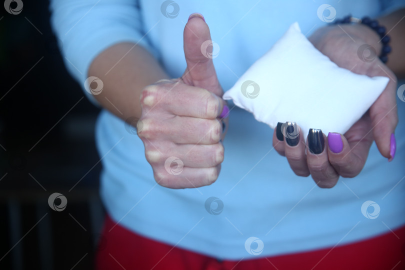 Скачать Женская рука держит подушку и показывает "класс" крупным планом фотосток Ozero
