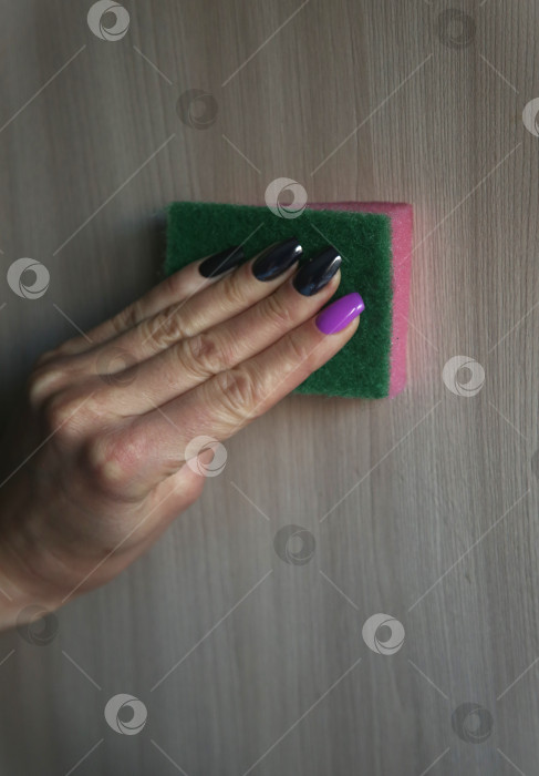 Скачать Женщина протирает пыль с помощью средства с распылителем и губки для уборки фотосток Ozero