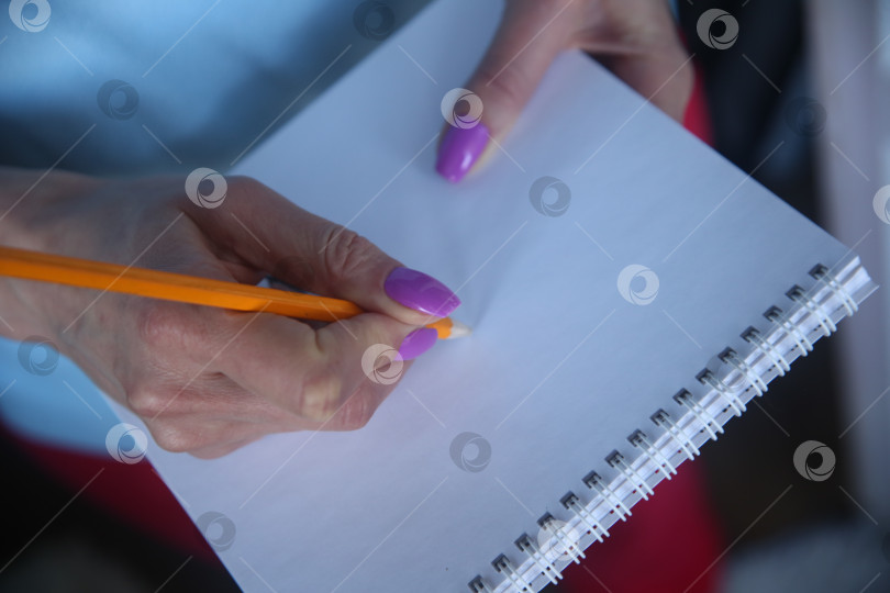 Скачать Девушка пишет карандашом текст, крупный план фотосток Ozero