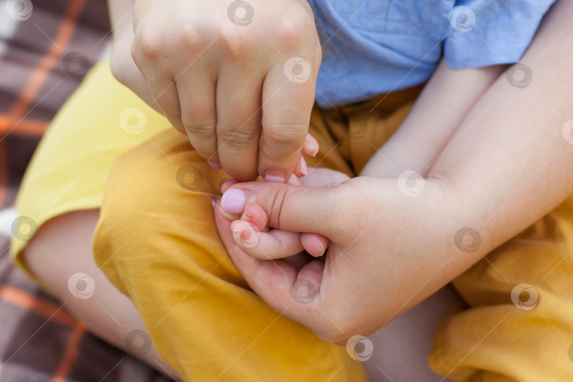 Скачать Крупный план матери, делающей массаж рук мальчику-инвалиду. дети-инвалиды. инклюзивность фотосток Ozero