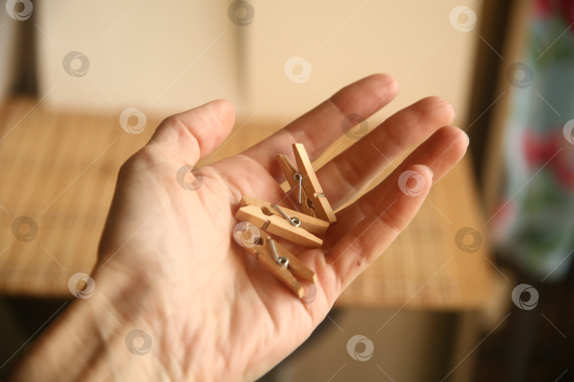 Скачать Деревянные прищепки для белья  в руке фотосток Ozero