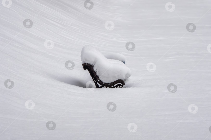Скачать Скамейка, покрытая снегом, стоит на снегу фотосток Ozero