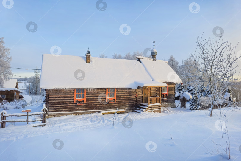 Скачать Красивая этническая маленькая бревенчатая хижина, деревянный храм, покрытый снегом. фотосток Ozero