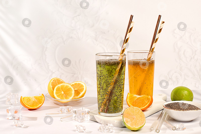 Скачать Современный натюрморт с цитрусовыми. Диетический веганский коктейль с семенами чиа, апельсином, лаймом, фиалкой и льдом. Концепция детокс-диеты и похудения. Летний баннер и шаблон для оформления экрана. фотосток Ozero