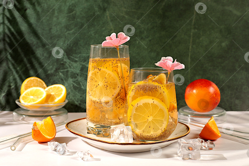 Скачать Диетический веганский коктейль с семенами чиа, апельсином, лаймом, фиалкой и льдом. Концепция детокс-диеты и похудения. Летняя вечеринка и реклама здорового образа жизни. Летний баннер и шаблон экрана. фотосток Ozero