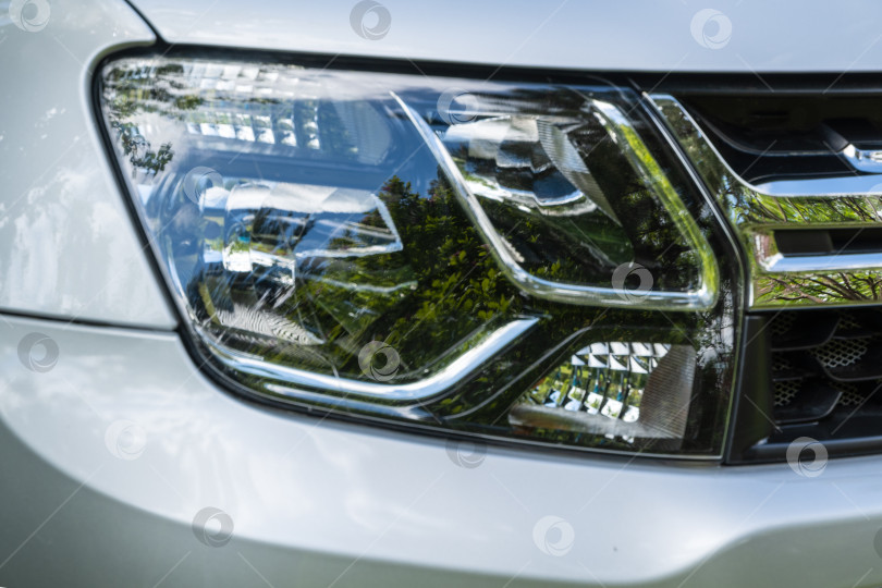 Скачать Внедорожник Renault Duster Adventure. Современная фара внедорожника Renault Duster Adventure. Крупный план. Оригинальный дизайн фары. Автомобиль серого цвета. фотосток Ozero