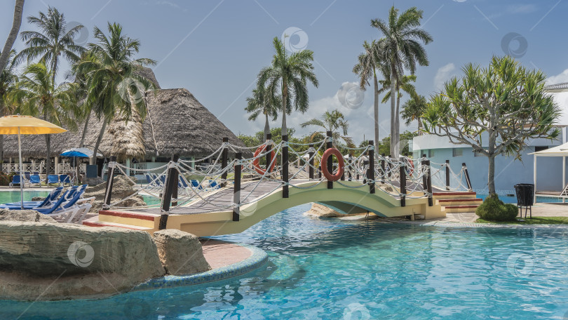 Скачать Открытый бассейн. Арочный пешеходный мост над аквамариновой водой. фотосток Ozero