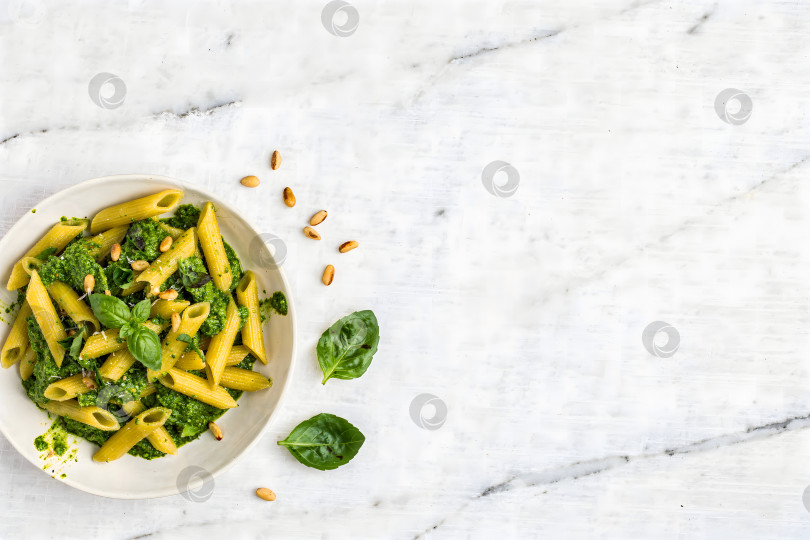 Скачать Пенне с песто и кедровыми орешками на мраморной поверхности фотосток Ozero