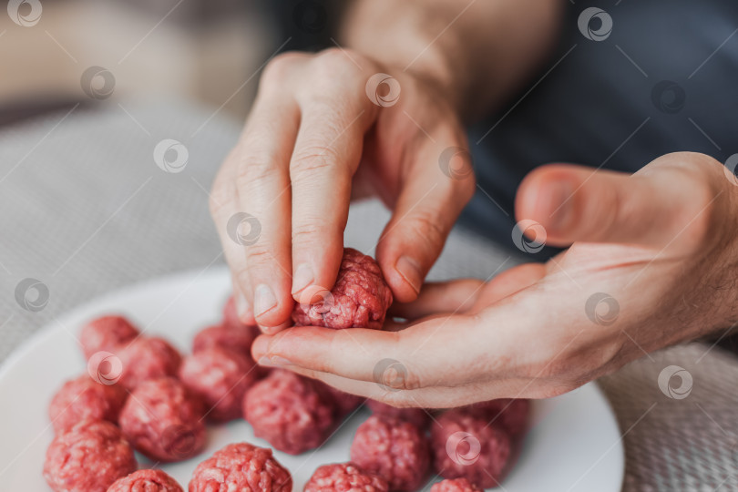 Скачать Мужские руки готовят фрикадельки из сырого мясного фарша фотосток Ozero