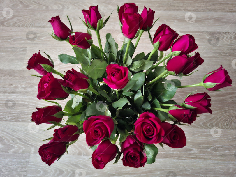 Скачать Букет мелких красных роз на деревянном фоне, вид сверху фотосток Ozero