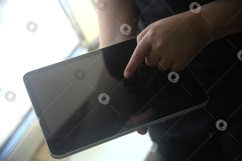 Скачать Рука мальчика указывает в планшете, крупный план фотосток Ozero