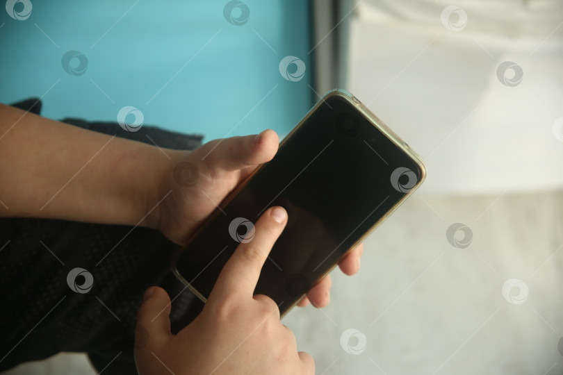 Скачать Мальчик указывает пальцем в телефон крупным планом фотосток Ozero