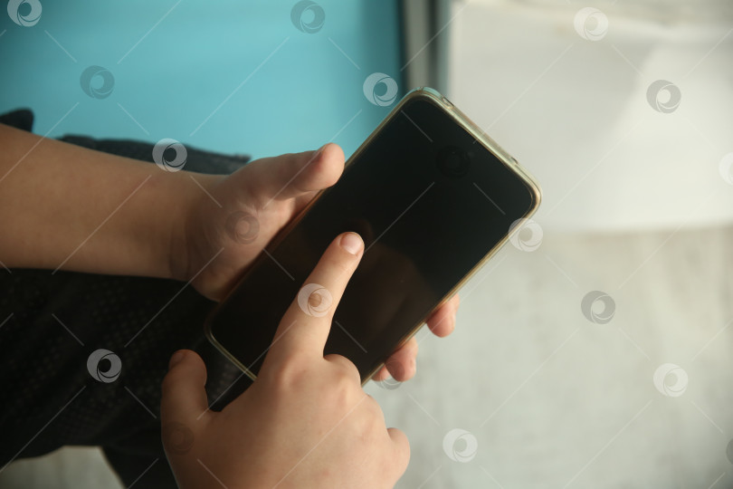 Скачать Рука мальчика указывает пальцем в телефон фотосток Ozero