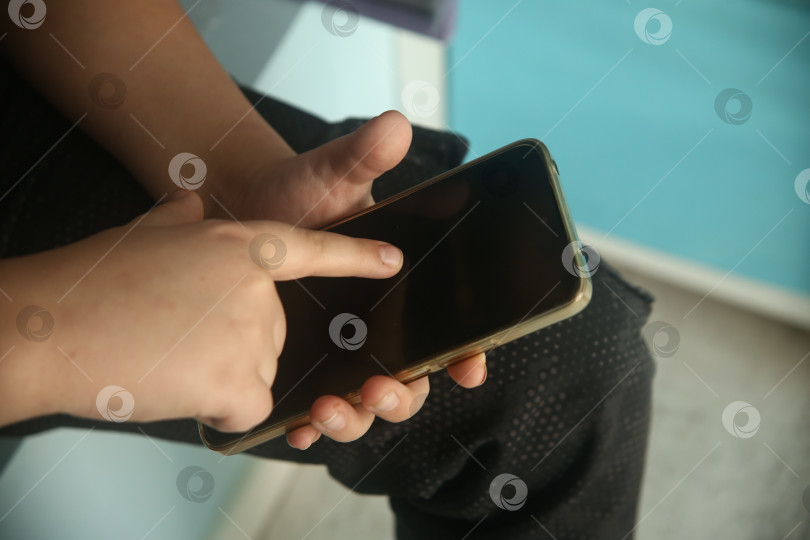 Скачать Рука мальчика указывает пальцем в телефон, крупный план фотосток Ozero