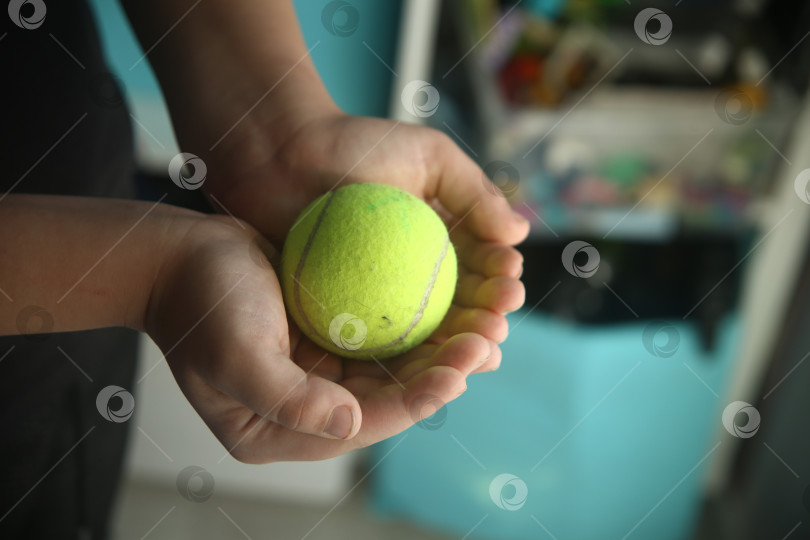 Скачать Ребенок держит бейсбольный салатовый мячик фотосток Ozero