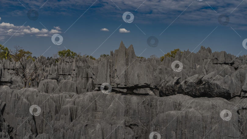 Скачать Крутые серые карстовые скалы на фоне голубого неба и облаков. фотосток Ozero